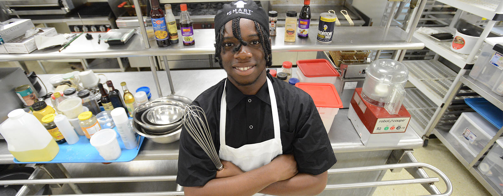 Culinary student posing for a picture in the kitchen.