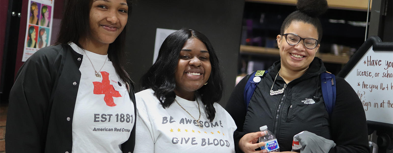 Students posing for a picture with a Red Cross employee during a blood drive.