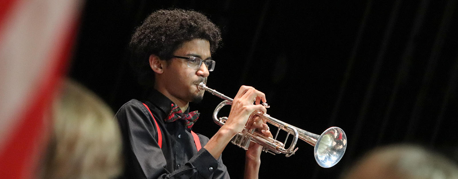 Student playing a trumpet during a concert.