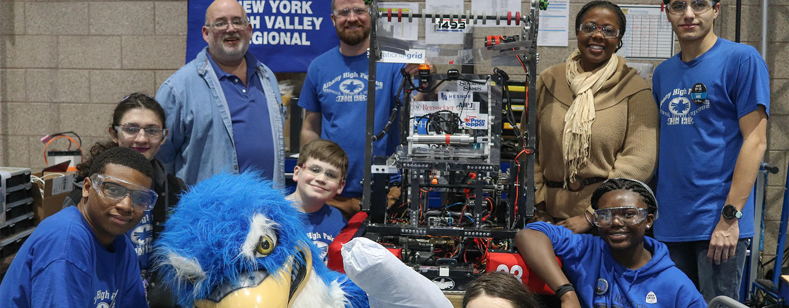 Robotics team posing for a group picture with the Albany High Falcon mascot.