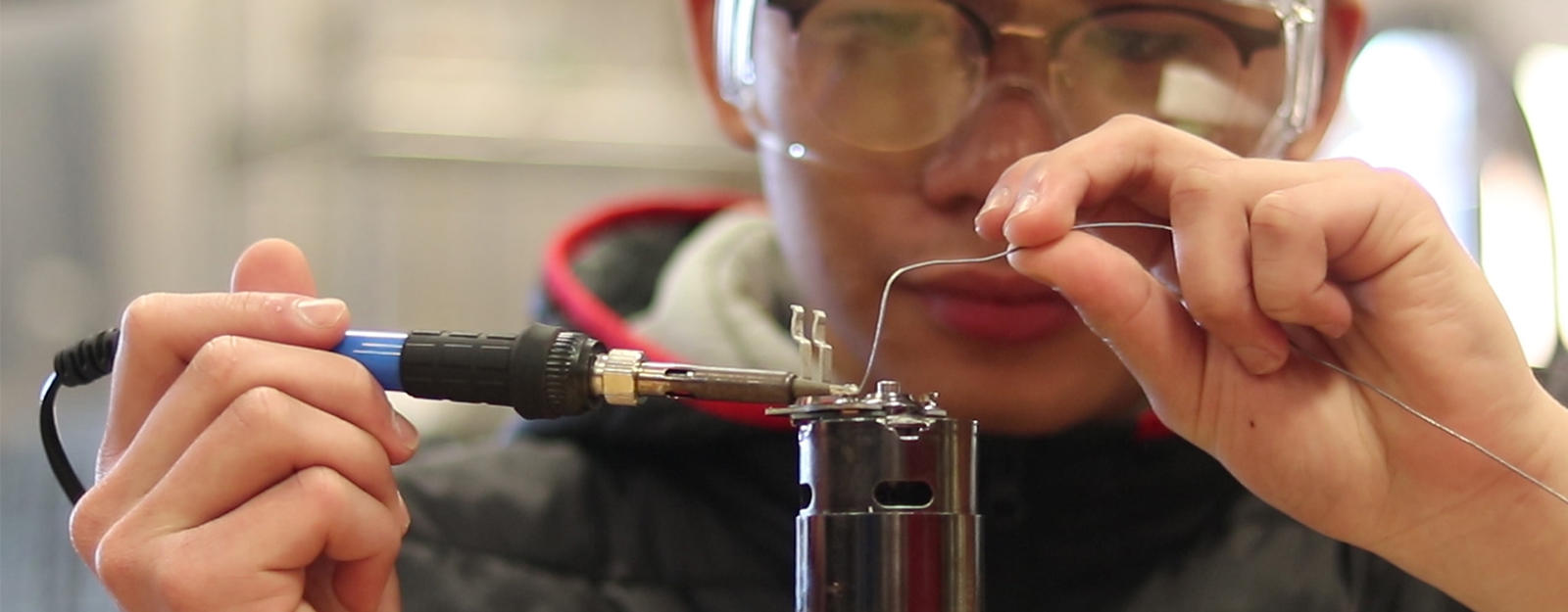 Student soldering a wire.