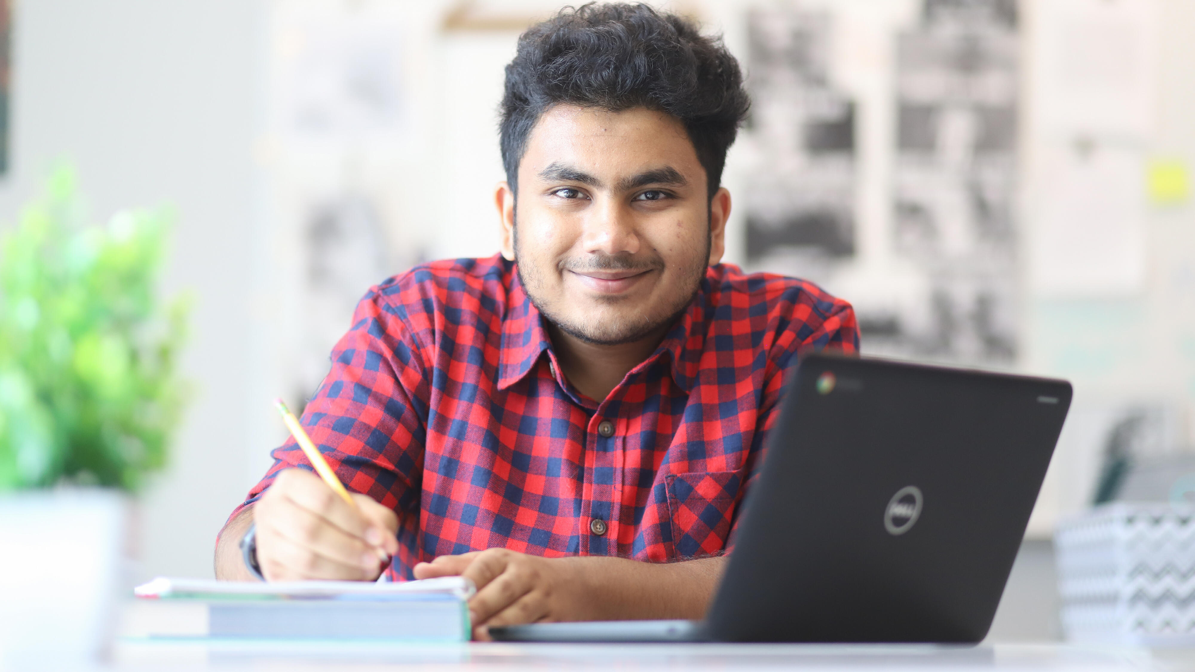 Student smiling and working on an assignment 