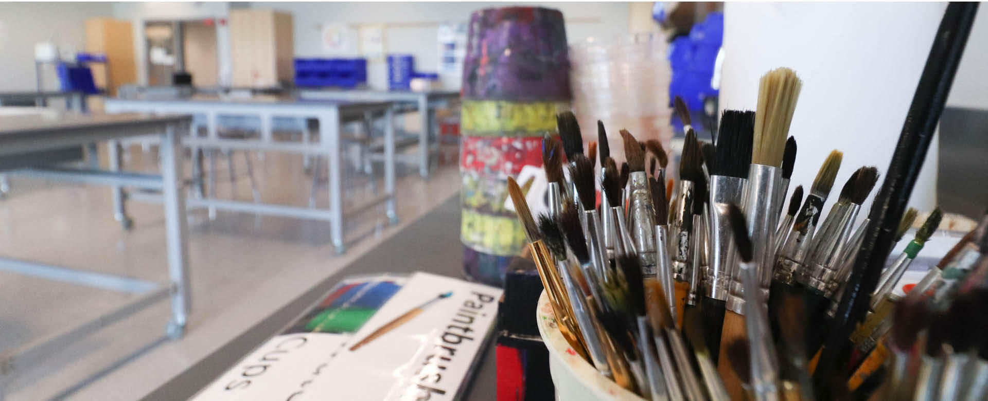 Paint brushes and art supplies on a counter.