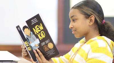 Student reading Jerry Craft's graphic novel "New Kid"