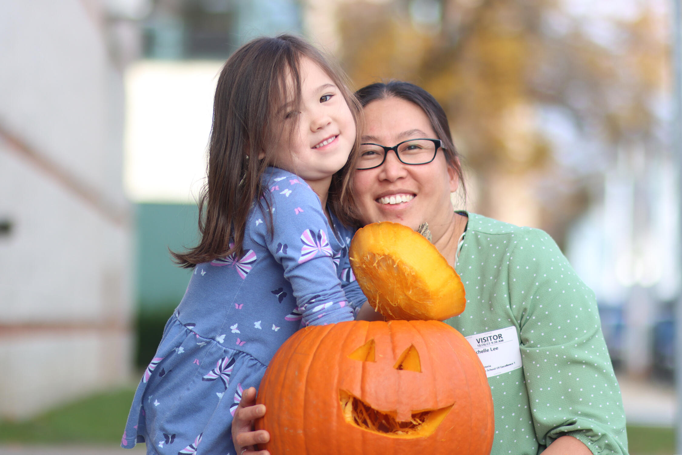 Student and their mother posing for a picture with the pumpkin they carved
