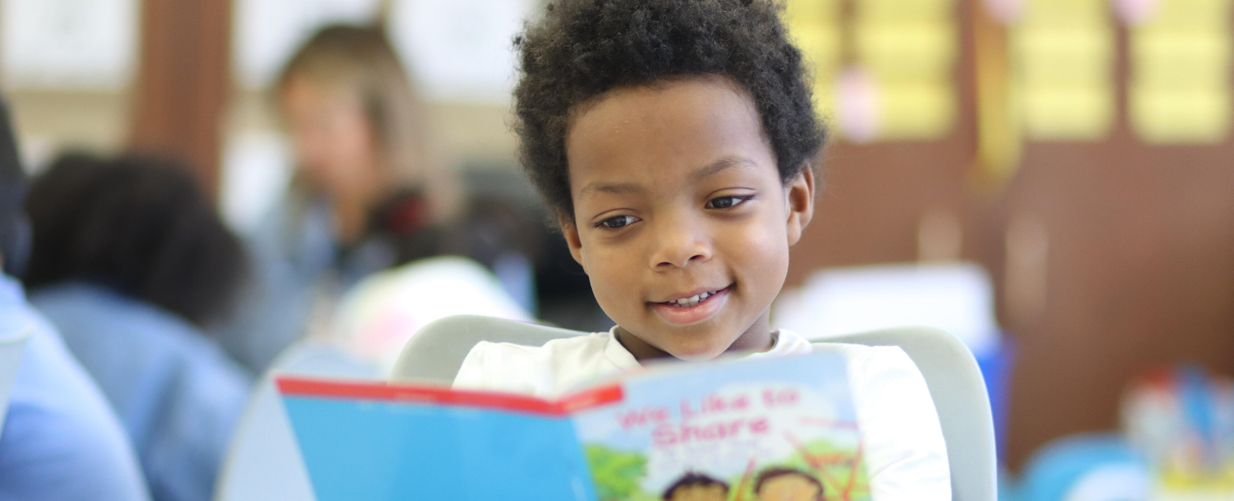 Elementary student smiling while reading
