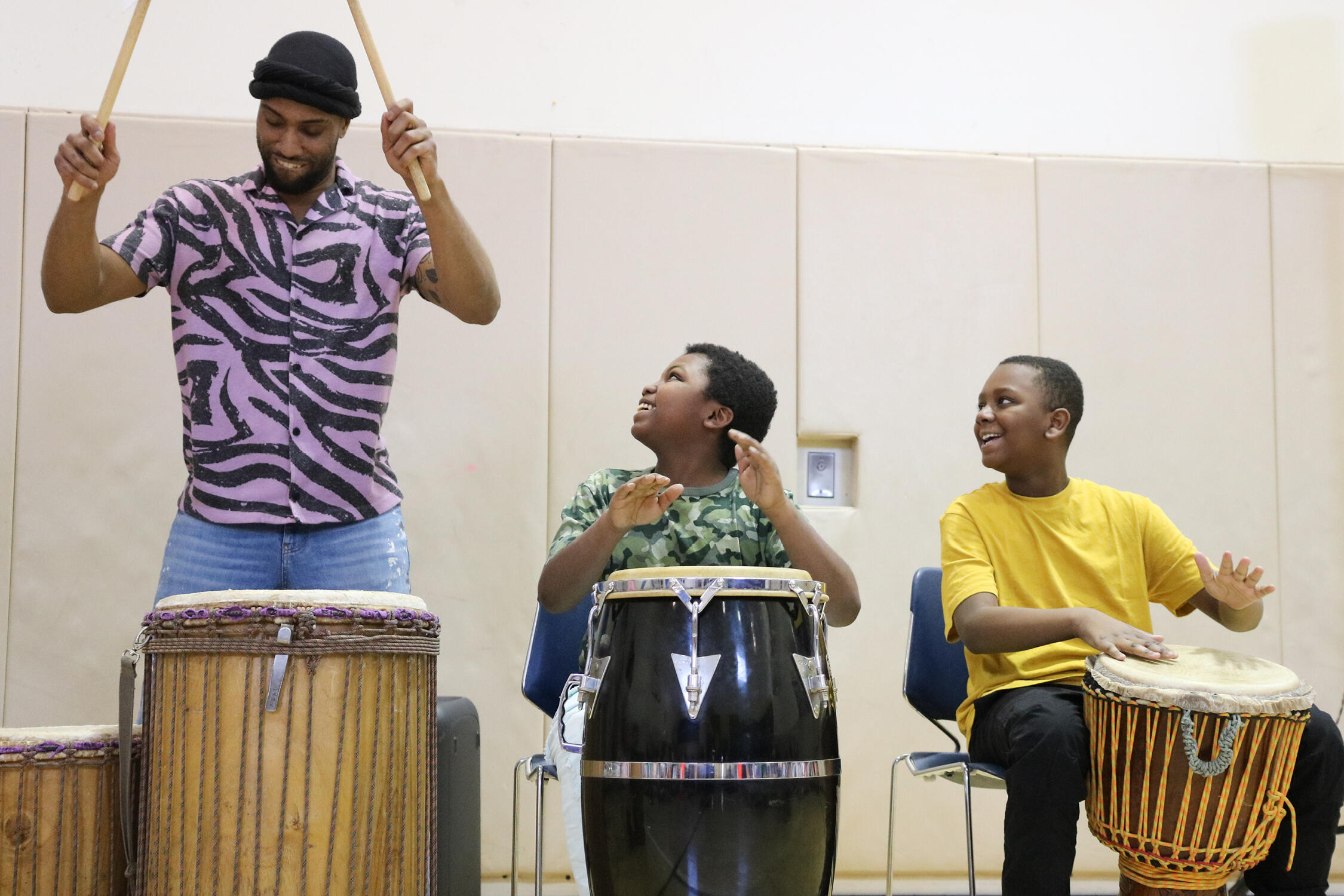 Students drumming with a community partner
