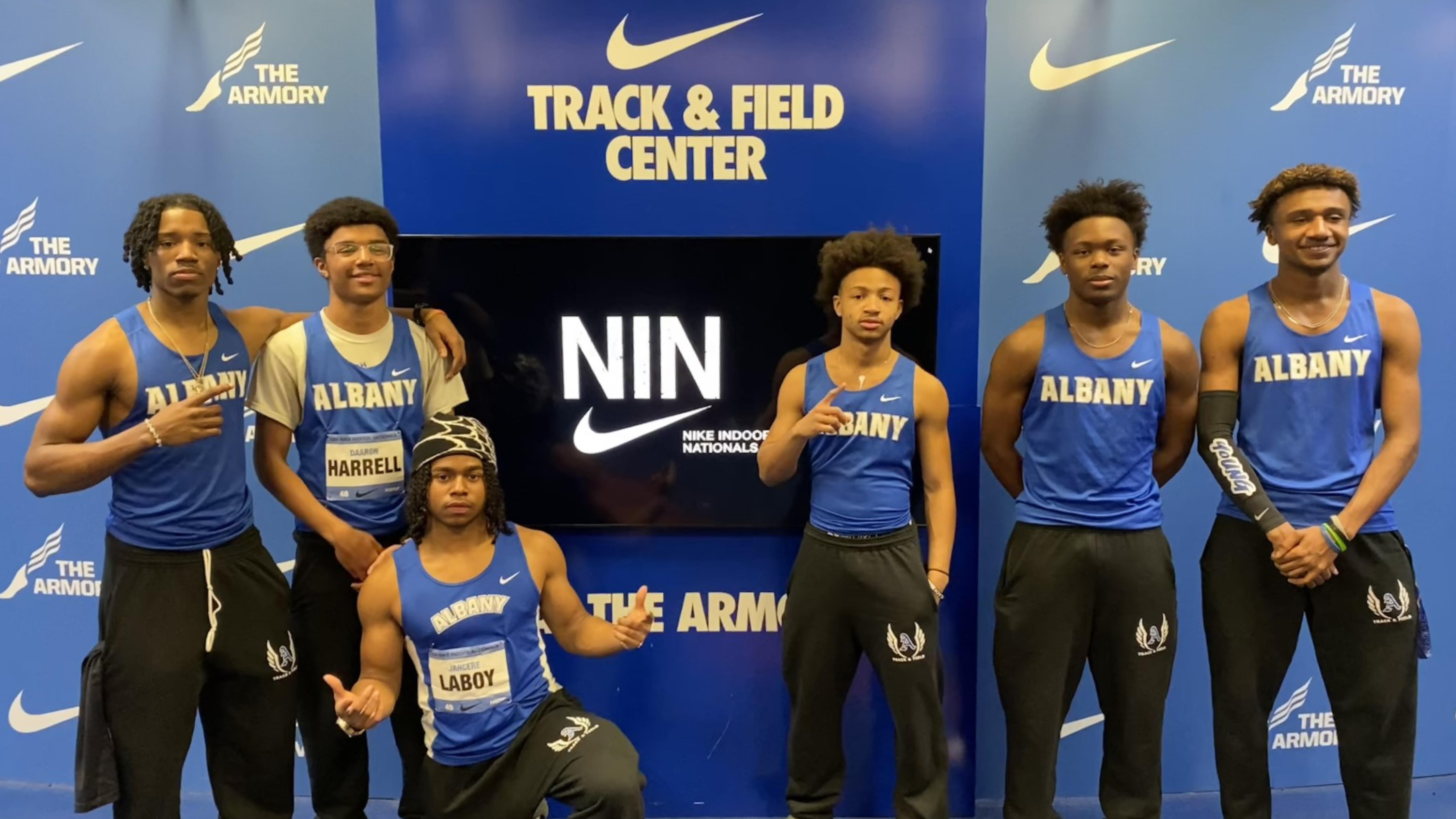 Albany High track members posing for a photo in front of the Nike backdrop