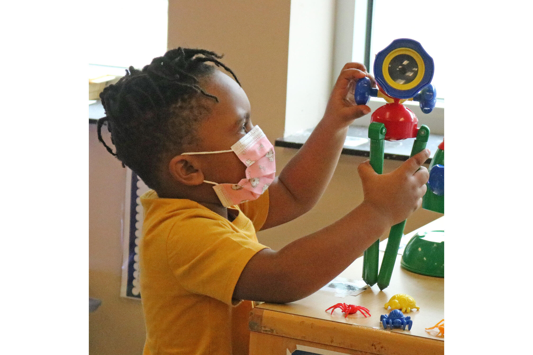 Pre-K student playing with a plastic science toy