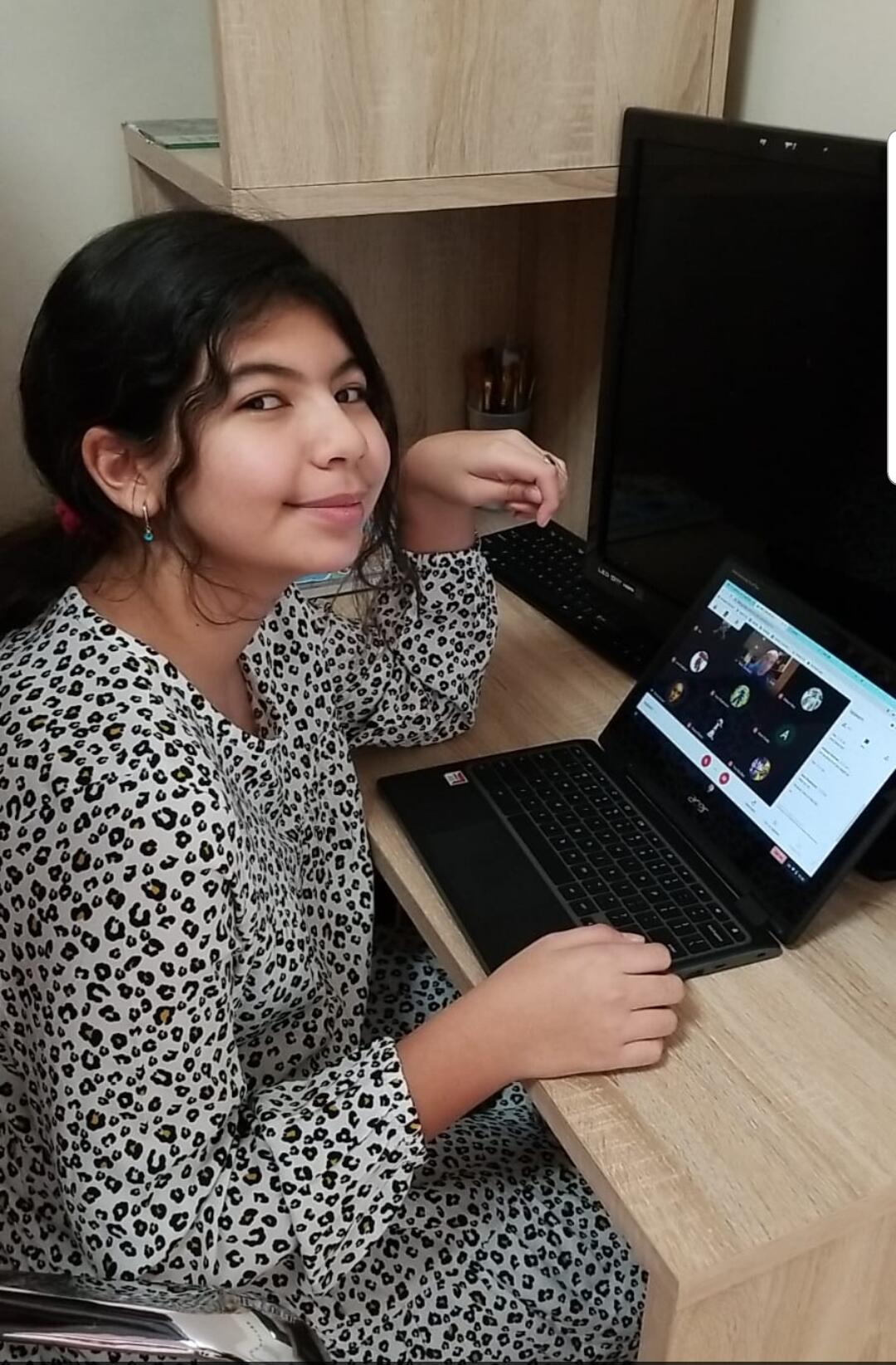 Virtual learning student posing for a picture at home with their laptop