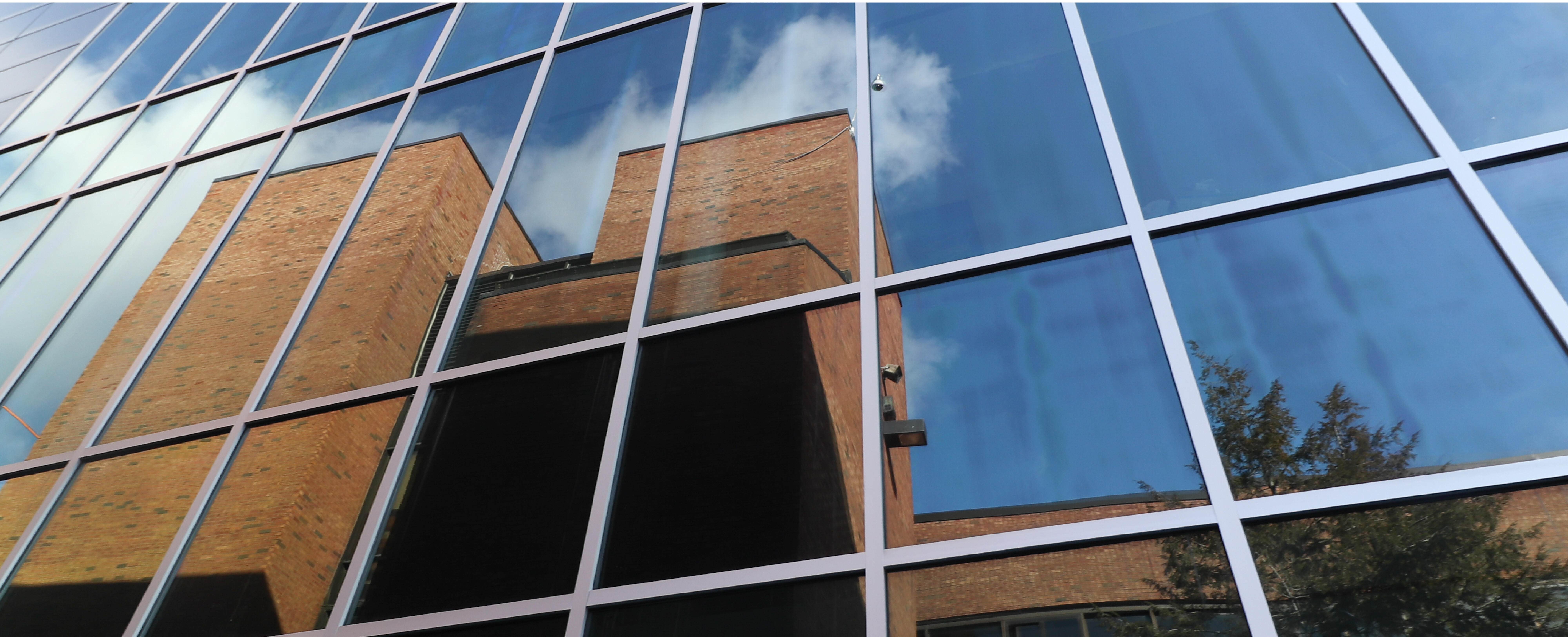 Photo of old Albany High reflected in the glass of the new academic building
