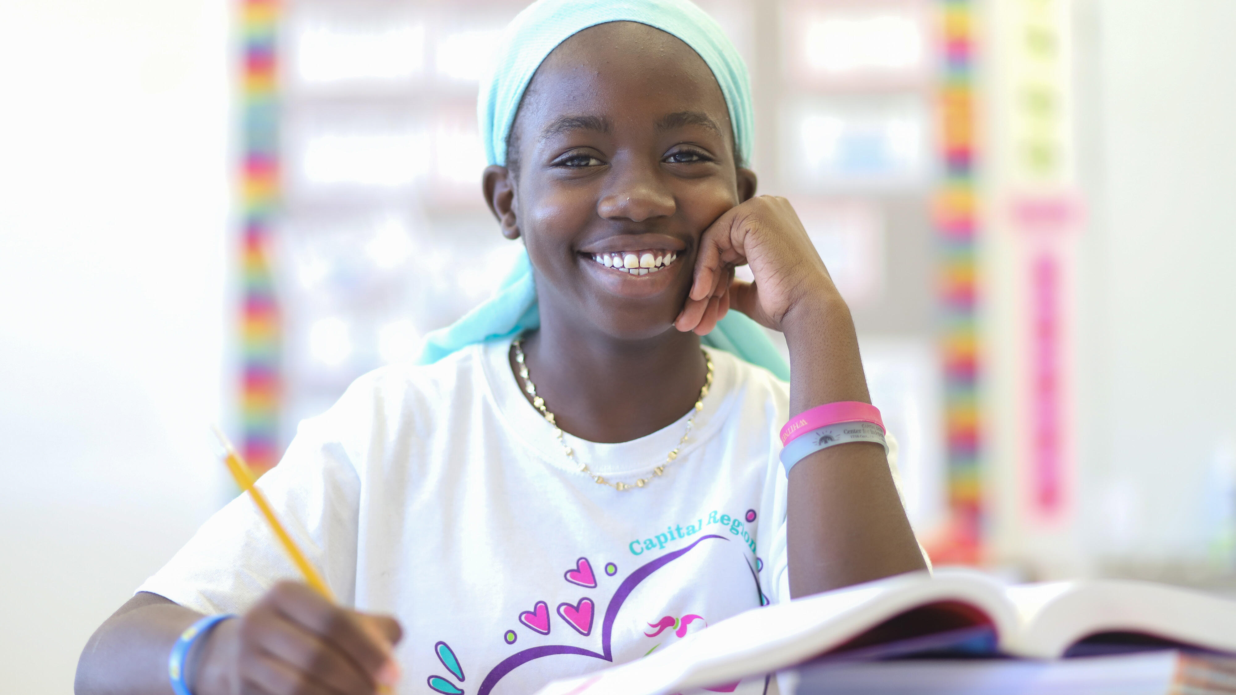 AIC student smiling and writing in a notebook