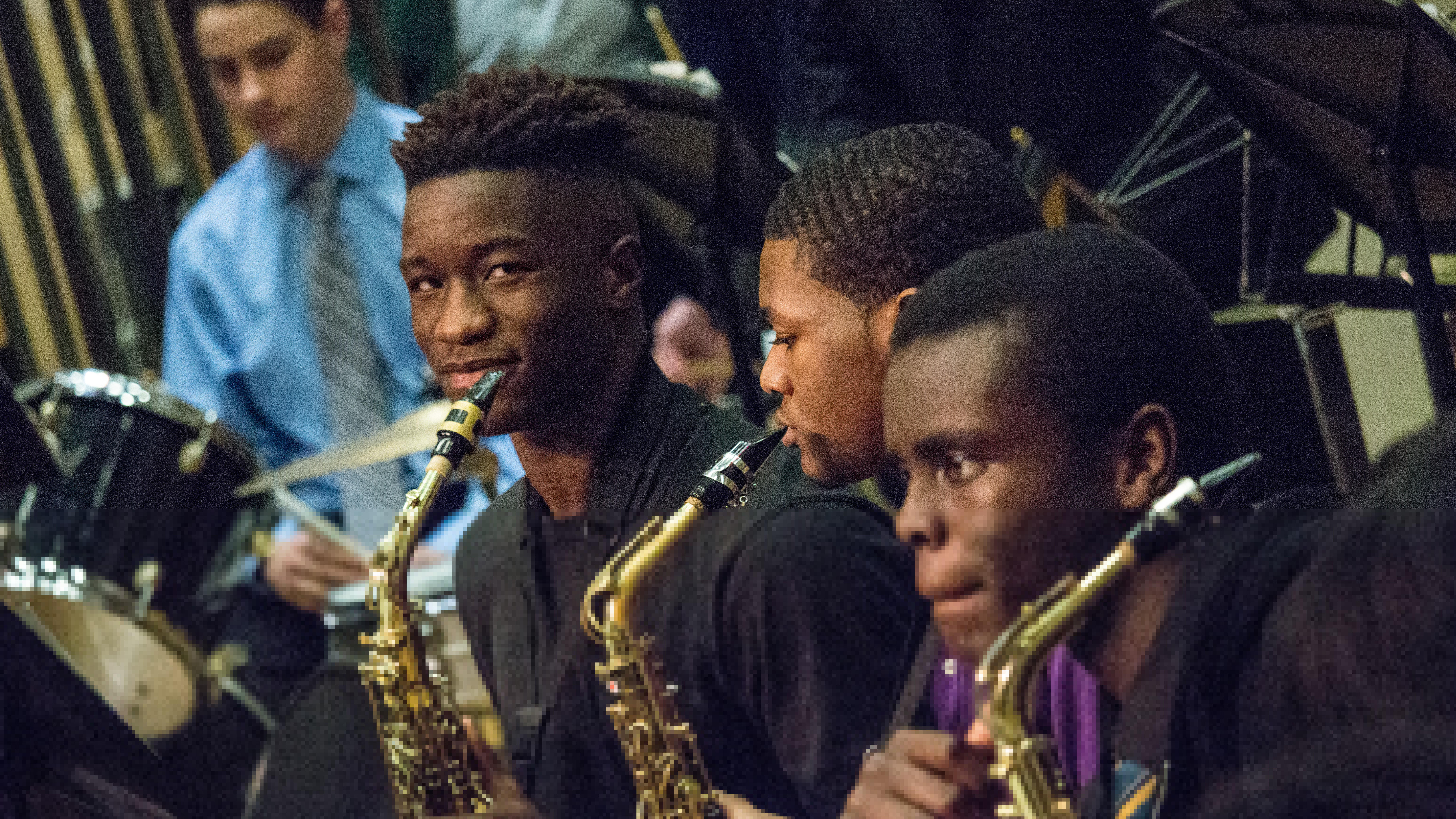 Students playing saxophone during a concert.