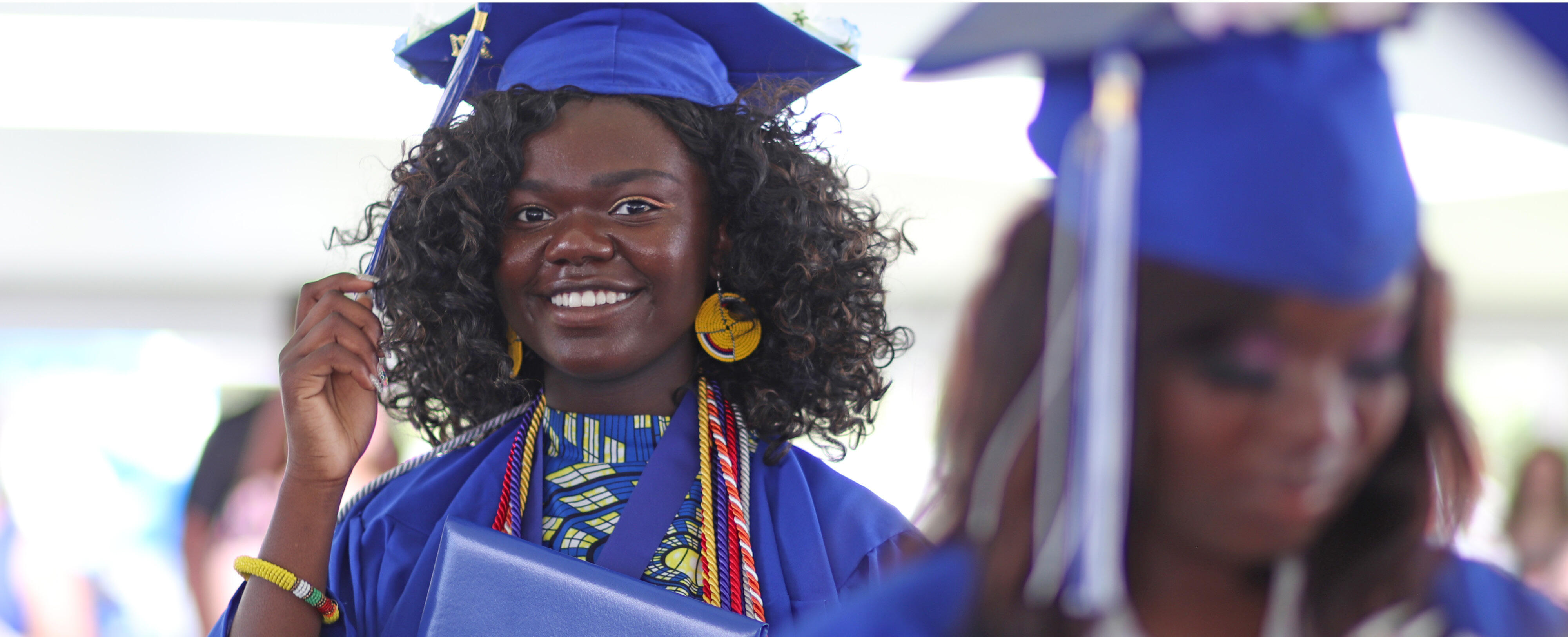 Photo of valedictorian Onovu-Otitigbe Dangerfield moving the tassel on her graduation cap