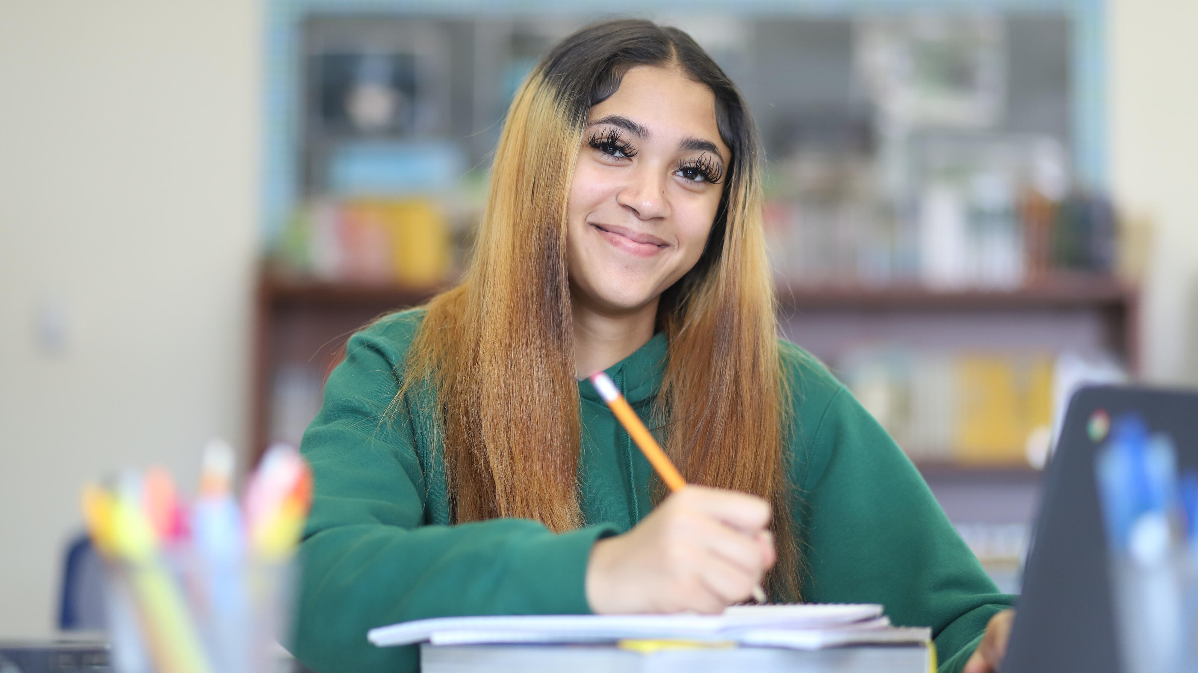 Student smiling while working on a math assignment