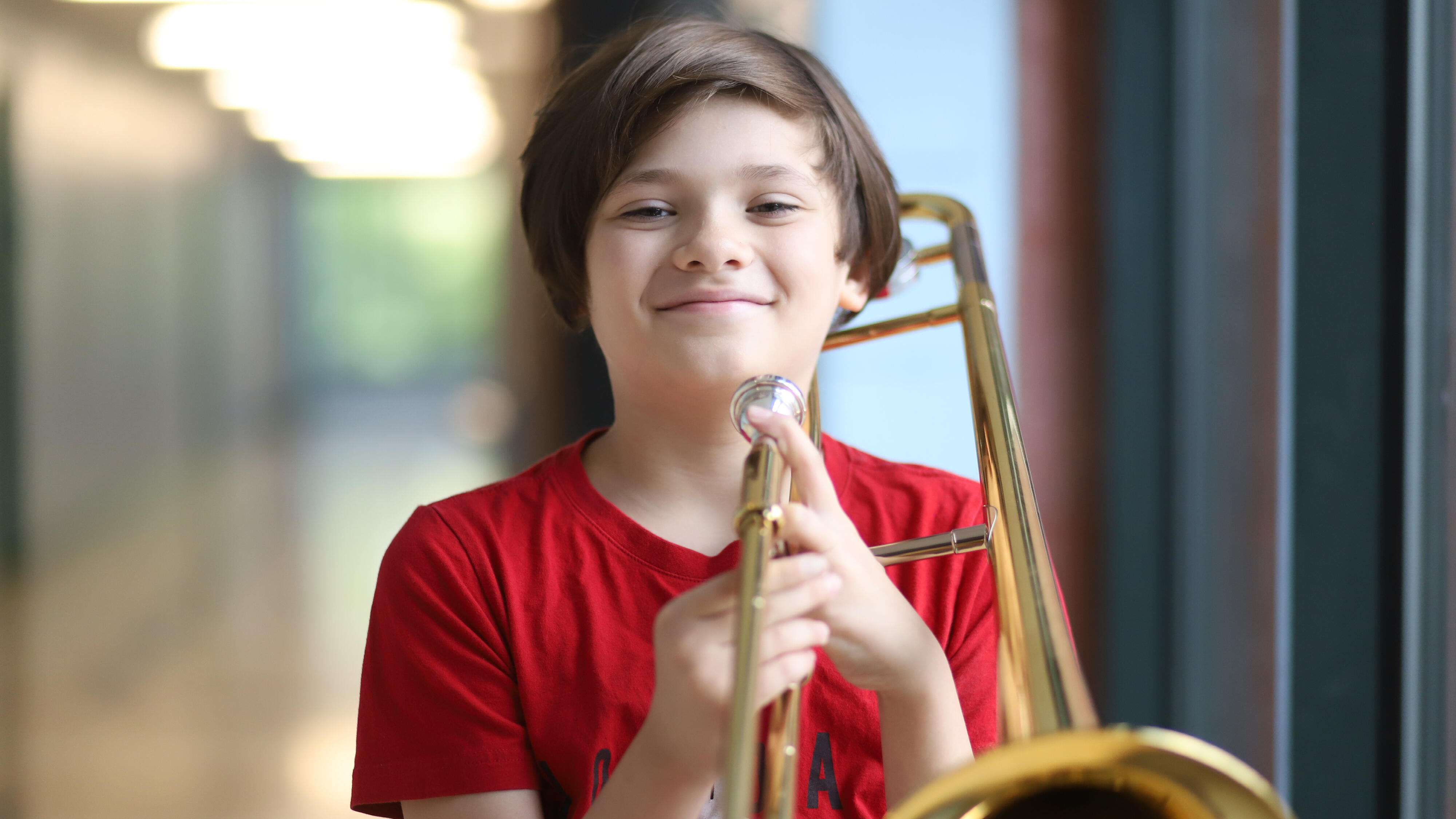 Student smiling while holding a trombone
