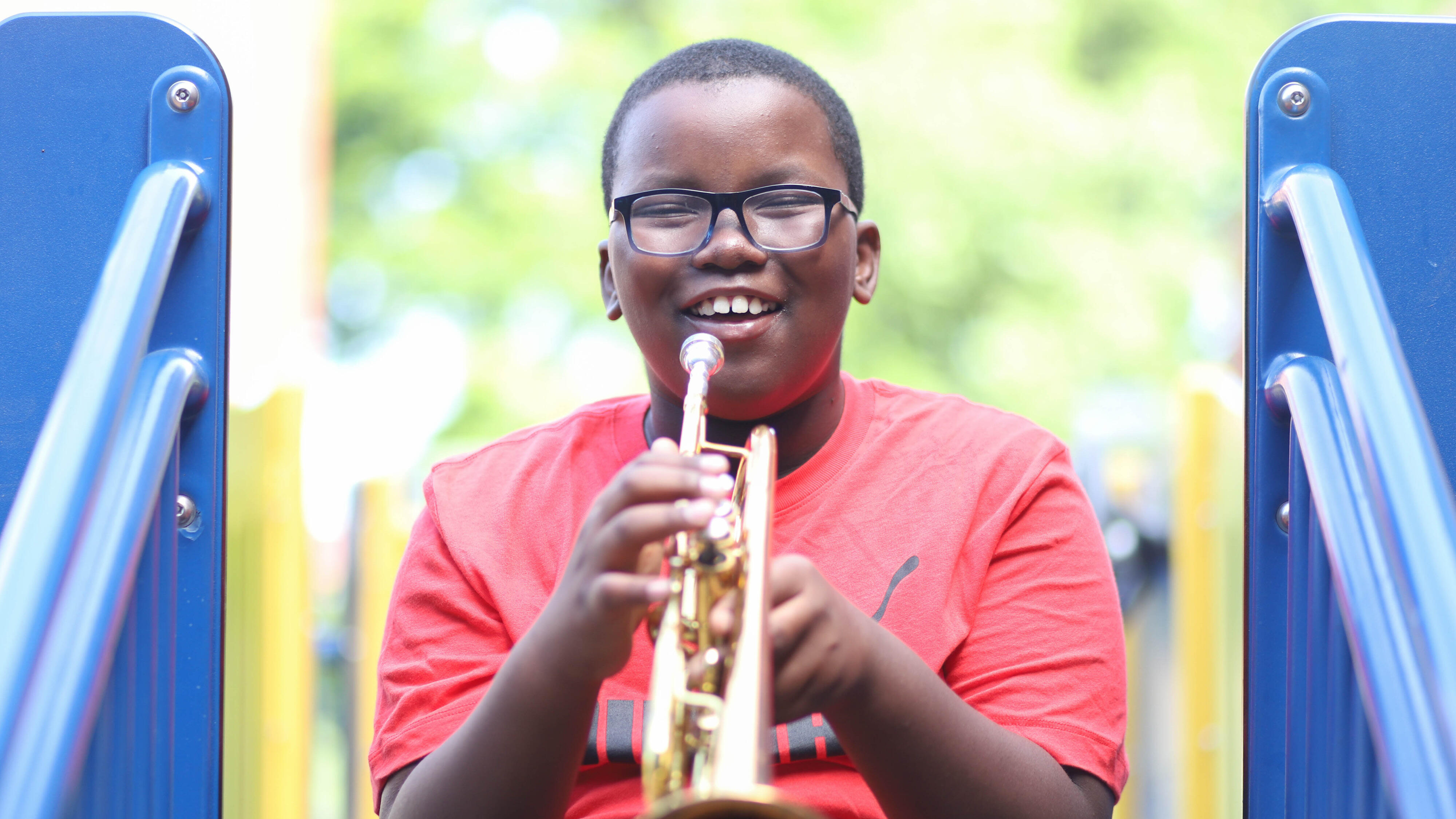 Student smiling and holding a trumpet