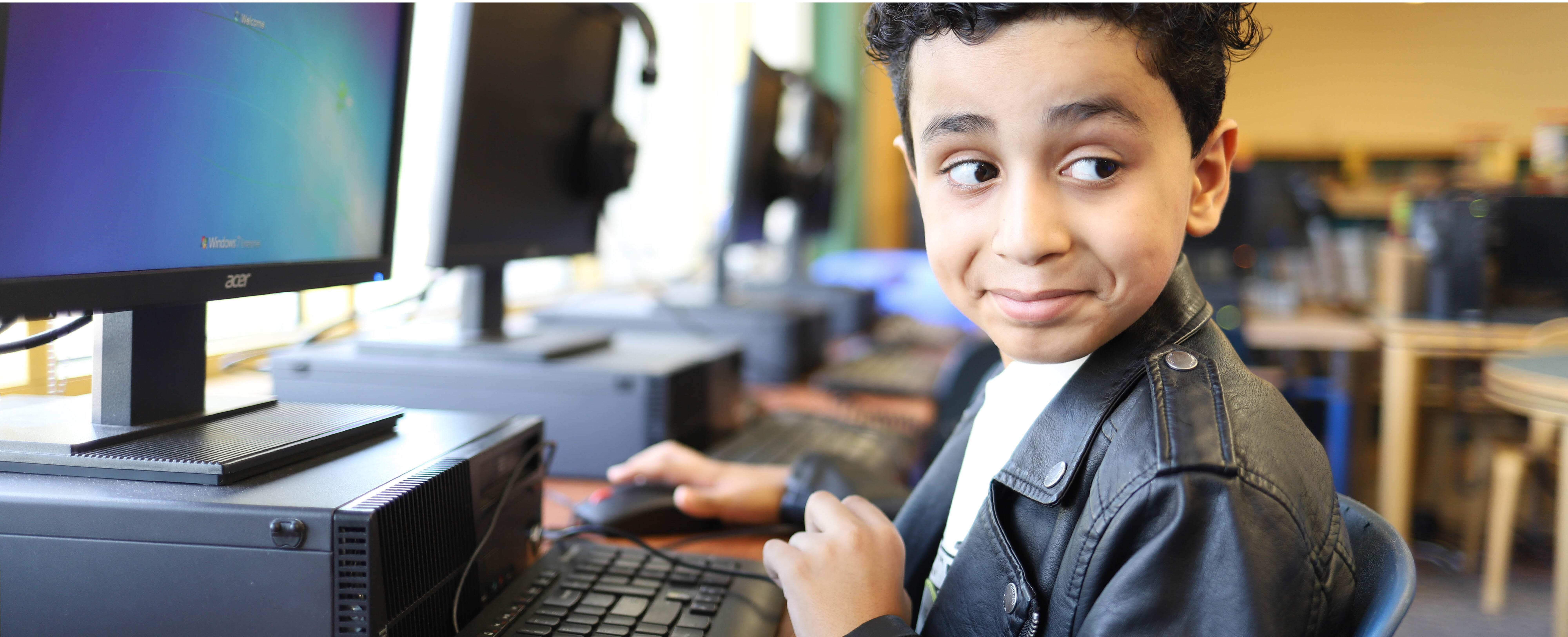 Student smiling while working on a computer
