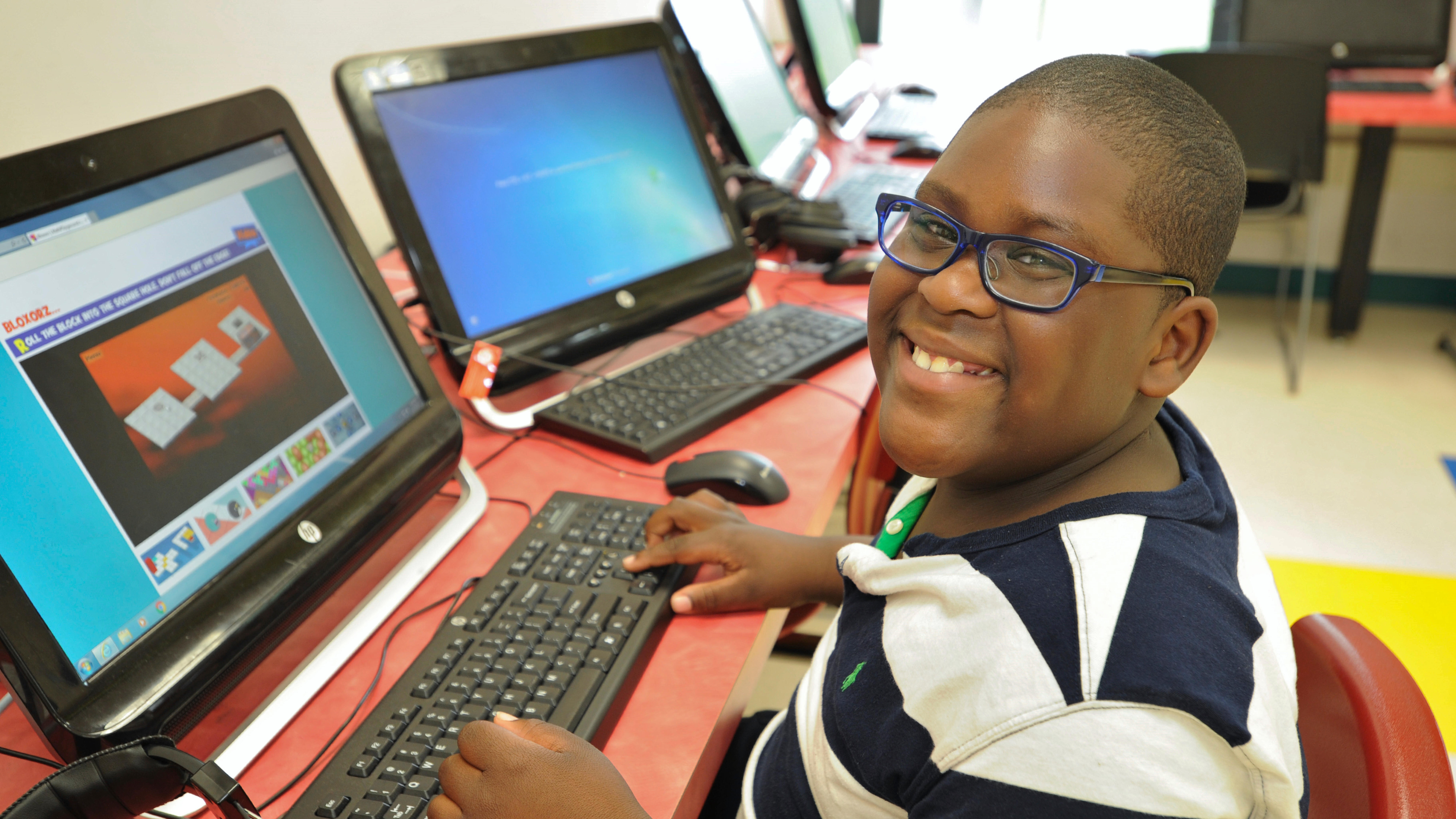 Special Education student smiling while working at a computer.